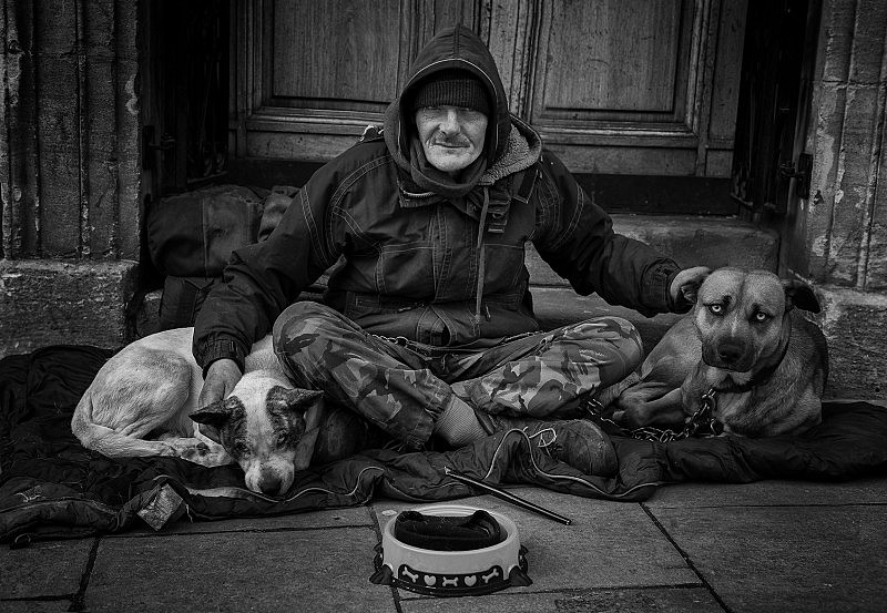 A street person on the streets of Bath with his two companion dogs