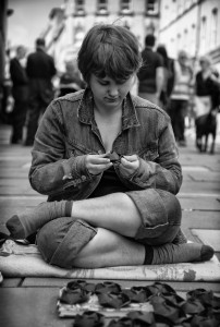 sitting girl with paper flowers- street photography from Bath