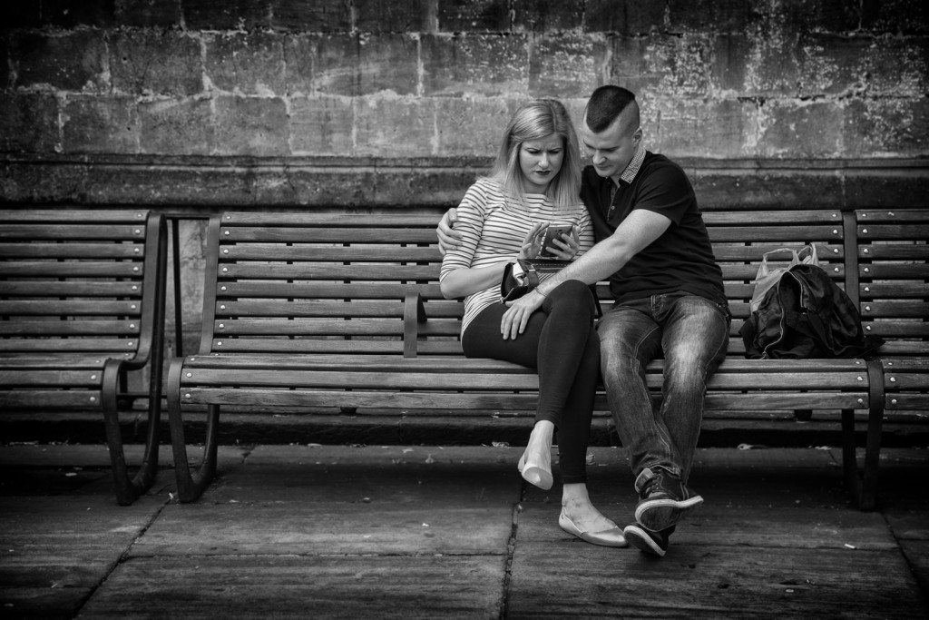 phone couple on a bench - UK street Photography